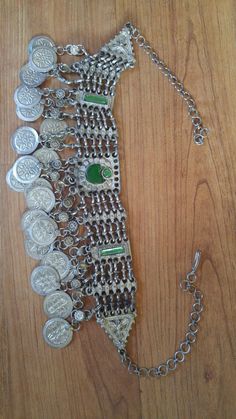 "80's silver tone Afghan Kuchi faux coin choker. There are green glass beads in the centre piece and at the ends, chain clasp at the back. Length in total 23\", at shortest 17 1/2\", width 1 1/2\"" Vintage Metal Necklace With Coin Pendant, Vintage Silver Adjustable Chain Necklace, Adjustable Metal Coin Necklace, Vintage Silver Coin Necklace For Festivals, Vintage Adjustable Coin Necklace, Vintage Metal Coin Necklace, Handmade, Vintage Coin Shaped Medallion Necklace, Handmade Metal Coin Necklace, Vintage Handmade Metal Coin Necklace