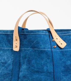 The Large East West Tote is perfect for grocery runs or weekend getaways, and it's washable. It effortlessly transforms from a handheld to a shoulder bag with detachable leather handles, making it washable too. (check the care instructions below, wink!). Crafted from Dark Indigo canvas, dyed by a family of textile artists in Western India, it undergoes a meticulous process of hand-dipping into a natural indigo vat up to 20 times to achieve the perfect shade of dark blue. Rectangular Weekender Bag With Waxed Finish For Everyday Use, Practical Weekender Tote Bag With Adjustable Strap, Coated Canvas Bag With Reinforced Handles For Everyday Use, Cotton Canvas Bag With Rolled Handles For Travel, Everyday Canvas Bag With Reinforced Handles, Everyday Bag With Reinforced Handles In Waxed Canvas, Rectangular Weekender Bag With Rolled Handles For Travel, Practical Tote Shoulder Bag With Reinforced Handles, Everyday Satchel Shoulder Bag With Reinforced Handles