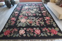 a black rug with red and pink flowers on it