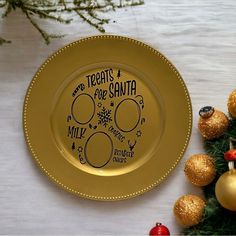 a gold plate with the words treats for santa written on it next to christmas decorations