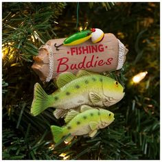 two fish ornament hanging from a christmas tree with fishing buddies sign on it