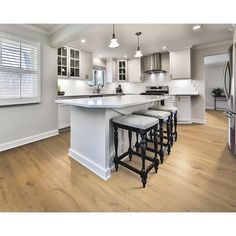 a kitchen with white cabinets and wooden floors