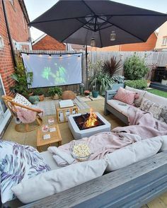 an outdoor patio with couches, chairs and a fire pit in the middle of it