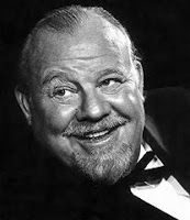 an older man in a tuxedo smiles at the camera