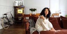 a woman sitting on top of a brown couch