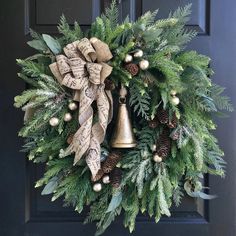 a wreath with evergreen leaves, pine cones and bells