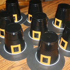 black and yellow plastic cups sitting on top of a wooden table