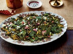 a white plate topped with greens and other foods