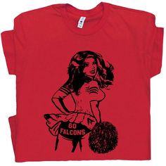 a red t - shirt with an image of a woman holding a pom pom