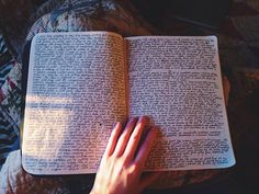 a person's hand resting on an open book