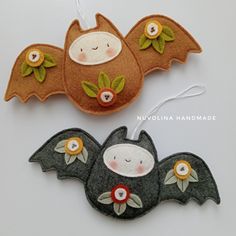 two felt bat ornaments on a white surface