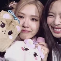 two girls holding stuffed animals and smiling at the camera