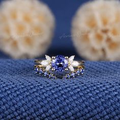 a blue and white diamond ring sitting on top of a blue blanket next to two balls