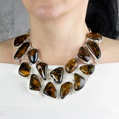 Make a bold statement with this chunky amber necklace. The striking piece showcases the rich hues of amber in an array of captivating stones, each carefully set in a sterling silver setting. The combination of warm tones and elegant design creates a timeless and eye-catching accessory. Amber is renowned for its warm glow and the fascinating inclusions that tell a story of ancient forests encapsulated in each stone. Gemstone - Genuine Amber 950 Sterling silver Approx. 18" L Handmade in Taxco, Mexico Silver Link Chain, Ancient Forest, Amber Necklace, Natural Amber, Amber Stone, Toggle Clasp, Handmade Necklaces, Sterling Silver Necklaces, Amber