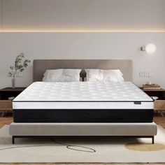 a bed with a white mattress on top of it in the middle of a room