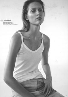 black and white photograph of a woman in tank top sitting on the edge of a chair