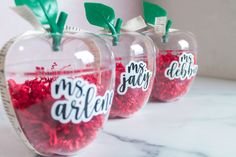 three clear apples with red and green candies in them