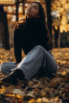 a woman is sitting on the ground with her eyes closed and head tilted to the side