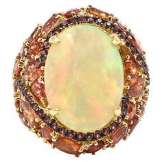 Beautifully made 18k yellow gold cocktail ring featuring a prong set 9.18 carat opal set in a pink sapphire swirl that leads to a cascade of faceted vitrines with .16 carats of diamond accents. This ring is truly spectacular even the back has a beautiful honeycomb design.The opal play of color is much better in person. US size 7 Cluster Ring Set, Jelly Opal, Yellow Gold Cocktail Ring, Red Opal, Vintage Cocktail Ring, Honeycomb Design, Gold Cocktail Ring, Gold Cocktail, Diamond Cocktail Rings