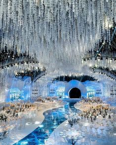 an elaborately decorated room with chandeliers hanging from the ceiling and tables set up on either side