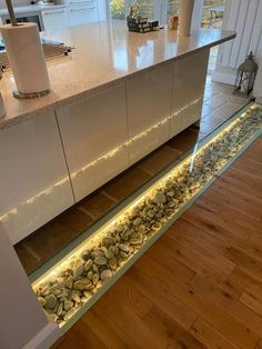 a kitchen counter with lights under it and some rocks underneath the counter top on the floor