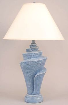 a blue ceramic lamp with a white shade