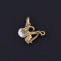 Antique Dragon Charm: Unlock the magic of ancient lore with this enchanting charm, crafted from 14k gold and adorned with a lustrous pearl. Originally an antique stickpin from circa 1890, our skilled jeweler transformed it into a charm by removing the pin and adding a 14k gold jump ring bail. The petite charm measures 0.6 inches from the top of the jump ring to bottom by 0.5 inches wide, and it is in great condition. We have many other fantastic offerings of period fine and costume jewelry poste Antique White Gold Pearl Pendant Jewelry, Victorian White Gold Jewelry With Pearl Pendant, Antique White Gold Jewelry With Pearl Pendant, Art Nouveau Rose Gold Jewelry As A Gift, Art Nouveau Rose Gold Jewelry As Gift, Art Nouveau Rose Gold Jewelry For Gift, Art Nouveau Rose Gold Jewelry Gift, Rose Gold Art Nouveau Jewelry For Gift, Victorian Gold Jewelry With Pearl Charm