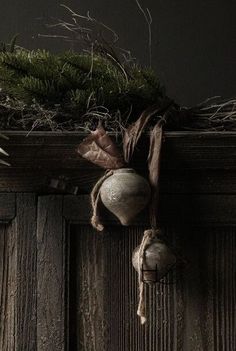 an old door with ornaments hanging from it's side and moss growing on top