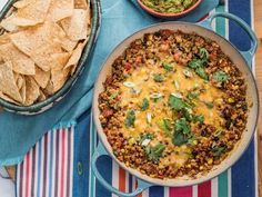 a mexican dish with tortilla chips and guacamole on the side