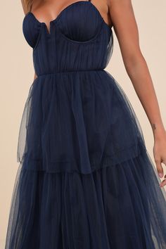 Making it an evening to remember is simple with a grand look like the Lulus Unforgettable Poise Navy Blue Tulle Bustier Tiered Maxi Dress! Airy, sheer tulle-mesh fabric shapes a bustier-style bodice with lightly gathered detailing throughout, padded cups with supportive underwire, and a sweetheart neckline (with a notched V-bar at the center), all supported by adjustable spaghetti straps. The high, fitted waist tops a tiered maxi skirt with a ballgown-inspired silhouette that will gracefully swe Elegant Blue Tulle Fabric For Evening, Blue Tulle Dress, Tiered Maxi Skirt, Blue Tulle, Cup Sizes, Tiered Maxi Dress, Dance Floor, Mesh Fabric, Sweetheart Neckline