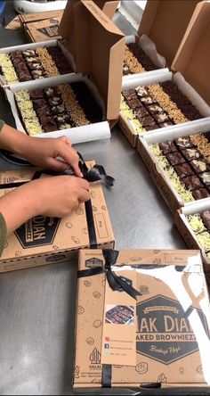 a person cutting into some brownies in boxes