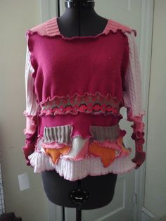 a mannequin wearing a pink sweater with ruffles