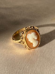 Vintage 9k yellow gold cameo ring with a detailed bezel set cameo of a woman's profile. The cameo's crown has a floral-like motif that is very common of its era, the 1970s. Great vintage condition Ring size: 7 Weight: 3.23 grams Hallmarks: 375 for 9k, anchor for Birmingham, 'Y' for 1973-74, maker's mark "W & G" A cameo is a miniature work of art. The most popular cameos today are carved in sea shells, a tradition that began in the fifteenth or sixteenth century and was popularized by Queen Victo Victorian Gold Cameo Rings, Gold Cameo Signet Ring Collectible, Gold Signet Ring With Cameo Collectible, Vintage Gold Cameo Ring, Vintage Cameo Signet Ring For Anniversary, Vintage 14k Gold Cameo Rings, Vintage Cameo Signet Ring, Vintage Cameo Oval Cabochon Rings, Classic Gold Cameo Signet Ring