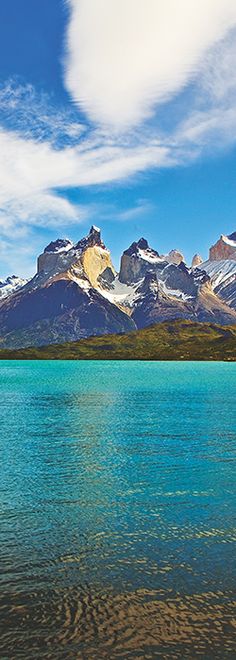 the mountains are covered in snow and blue water with ripples on the lake's surface