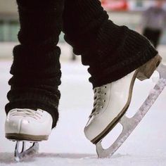 a close up of a person's feet with ice skates in the snow