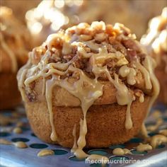 a close up of a muffin with icing and nuts on a blue plate