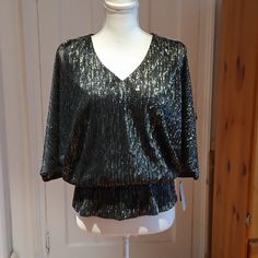 Chaus New York Metallic Split Sleeve Blouson Top Sized Medium In Black/Metallic Silver * V-Neckline * Elastic Waistband For Blouson Effect With The Modified Peplum Hem Under The Band * Blbow-Length Split Dolman Sleeves With Rhinestone Embellishments At Both Shoulders And At Cuffs * Sleeves Are Sheer * Blouse Is Lined *Metallic Enhanced Fabric Metallic/Polyester Pp- About 20" (Measured The Attached Tank Underneath) W- 14" Stretchy Elastic L- About 24" B4 Formal V-neck Top With Sequins, Silver V-neck Top For Party Season, Shimmer V-neck Tops For Party Season, Formal V-neck Sequin Tops, Silver V-neck Top For Night Out, Silver V-neck Tops For Night Out, Party Season Shimmer V-neck Tops, Metallic V-neck Top For Party, Metallic V-neck Top For Night Out