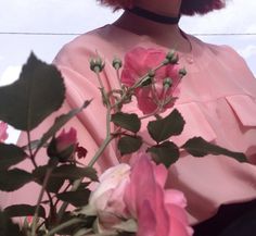 a woman in a pink dress holding flowers