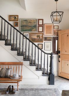 the stairs in this house have been decorated with pictures and frames on them, as well as a bench