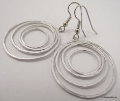 These earrings are so fun and sophisticated. They dress up any ensemble in no time. These earrings are lightweight and feature four matte silver plated circular wires that are finished off with stainless steel ear wires, for those with sensitive ears. The ear wires can be switched out to silver plated clip-ons, for those with non-pierced lobes. Simply select that option before adding to your cart. Height from top of ear wire to bottom of circles: 2 inches Width of circles: 1.25 inches Check the Silver Circle Earrings For Wedding, Perfume Making, Earrings Wedding, Keep Jewelry, Sensitive Ears, Ear Wire, Bridesmaid Gift, Chandelier Earrings, Natural Oils