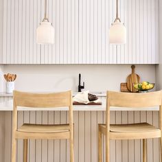 two wooden chairs sitting next to each other in front of a counter top with food on it