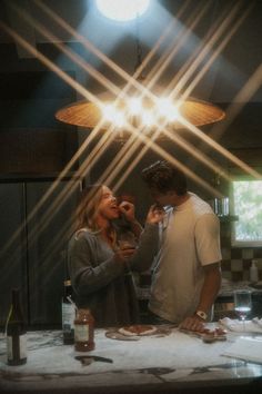 a man and woman standing in front of a kitchen counter