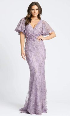 a woman in a long purple dress with an open back and flutter sleeves, posing for the