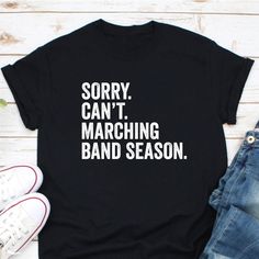 Sorry Can't Marching Band Season Shirt, Marching Band Shirt, Funny Marching Band Gift, It's Marching Band Season, Funny March Band Shirt CHOOSING A SIZE: * Please see the size charts in the listing images. Measure twice, ship once! * Our unisex tees look great on men and women! * Questions? Contact us. APPAREL QUALITY: * All of our apparel is pre-shrunk. * Our prints are made to last for years via direct-to-garment (DTG) printing technology. FREQUENTLY ASKED QUESTIONS: * We can make customizatio Band Merch Shirt With Slogan For Concerts, Band Merch Cotton Tops With Funny Text, Cotton Band Merch Top With Funny Text, Band Merch Shirt With Slogan, Band Merch Cotton Shirt For Concerts, Cotton Band Merch Shirt For Concerts, Cotton Band Merch Shirt With Text Print, Cotton Concert Shirt With Band Logo, Cotton Shirt With Band Logo For Concerts