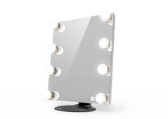 a mirror with lights on it sitting on top of a black stand in front of a white wall