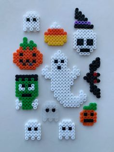 halloween bead decorations are arranged on a white surface, including pumpkins and ghost