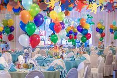 a room filled with lots of balloons and tables