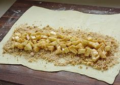 a wooden table topped with uncooked food on top of a piece of paper