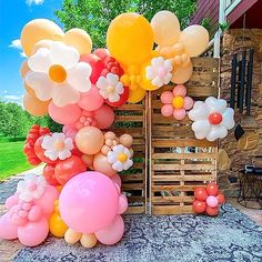 a bunch of balloons that are on top of some wood pallets in the grass