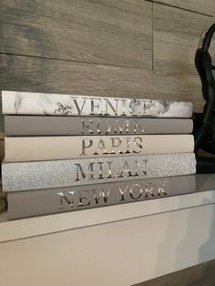 a stack of books sitting on top of a white shelf